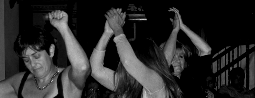 three women with arms up as if dancing to music with faces partially or fully obscured by arms or hair